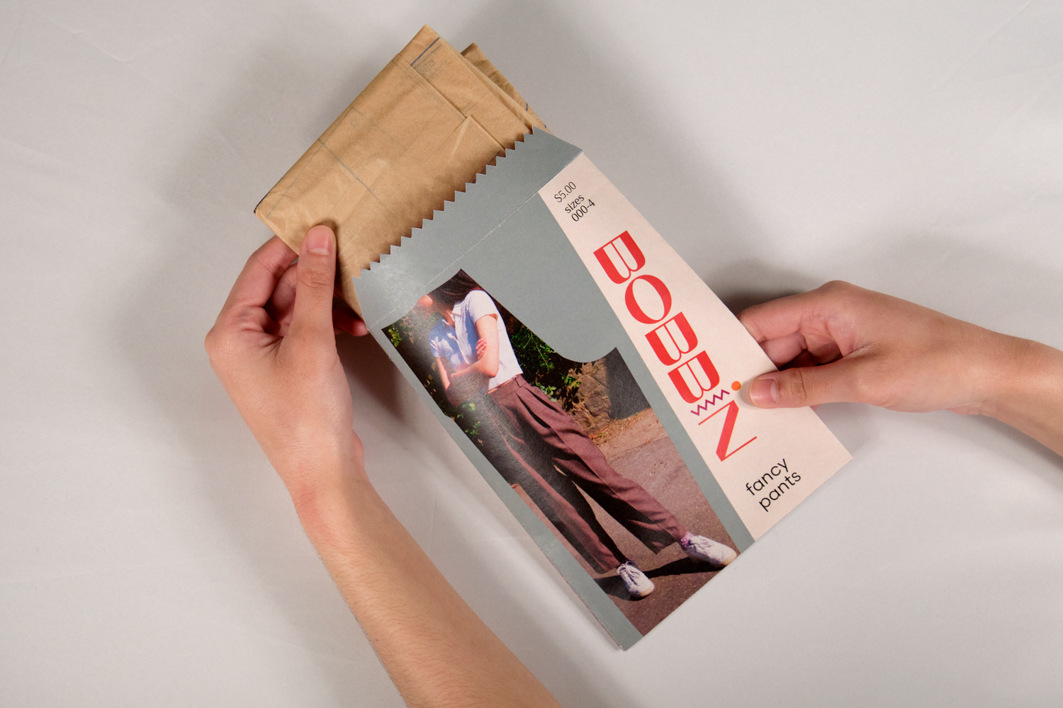 Hand pulling sewing pattern from envelope