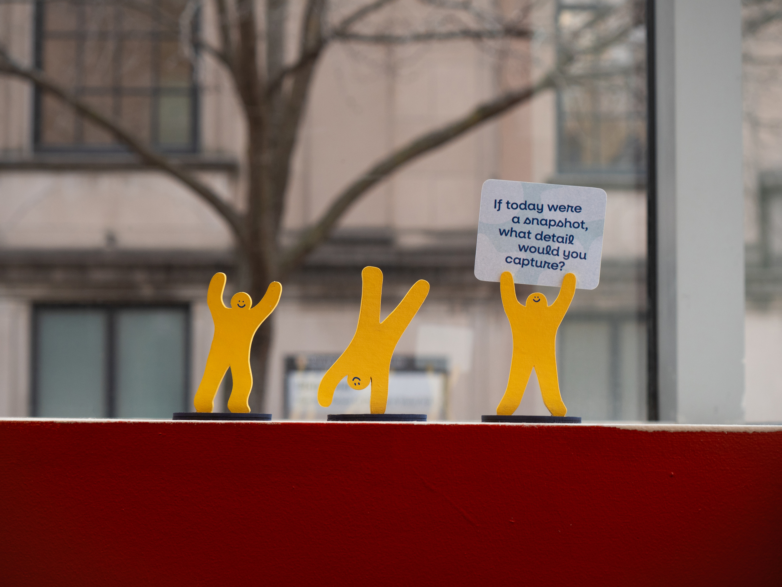 Small people cutouts cartwheeling and holding a cheerful sign