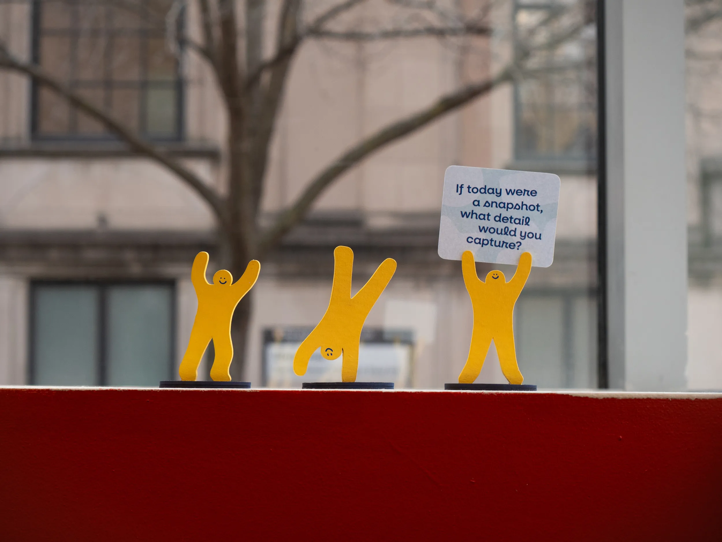 Small people cutouts cartwheeling and holding a cheerful sign