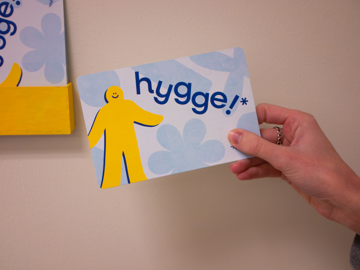 Hand holding front of Hygge postcard