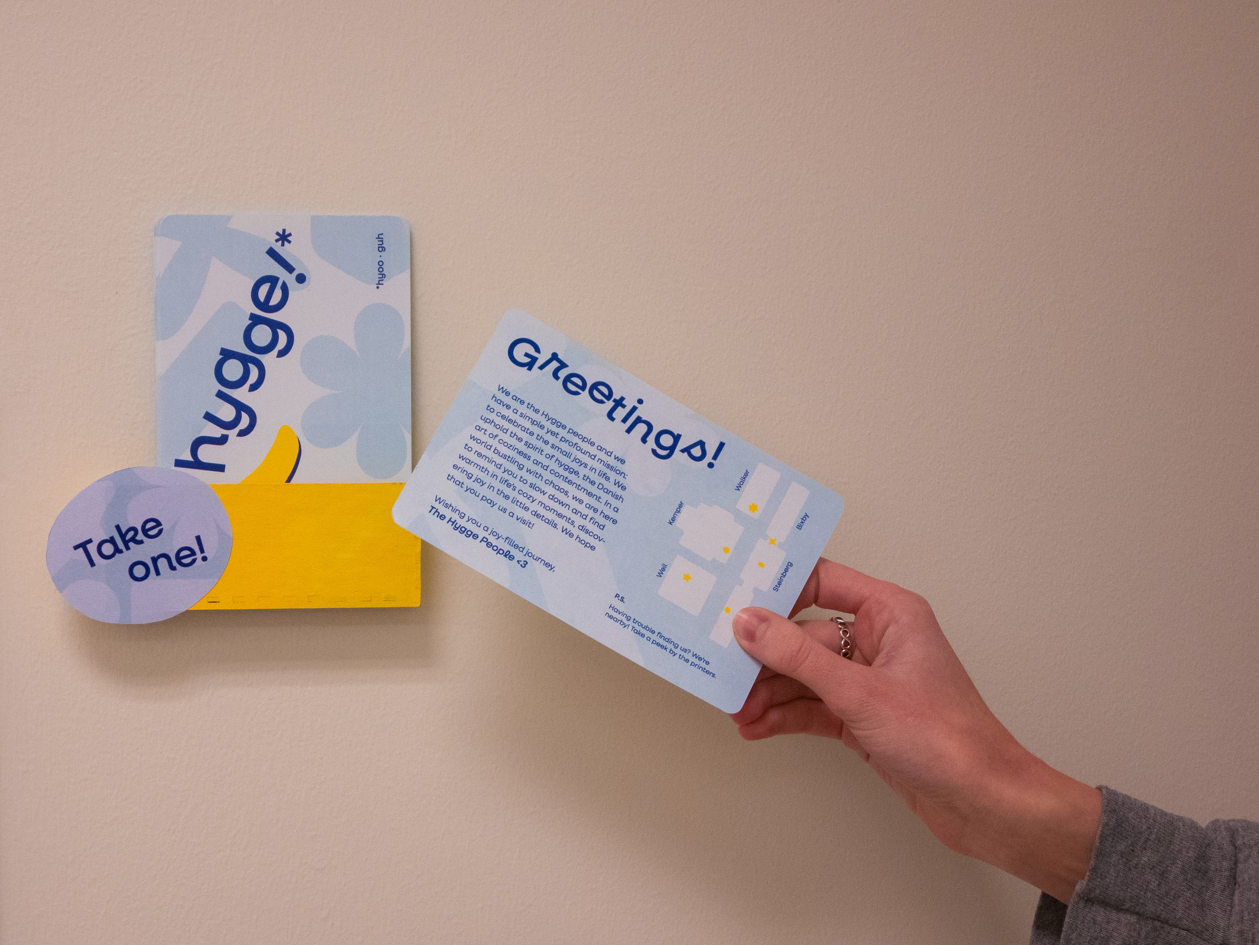 Hand holding back of Hygge postcard