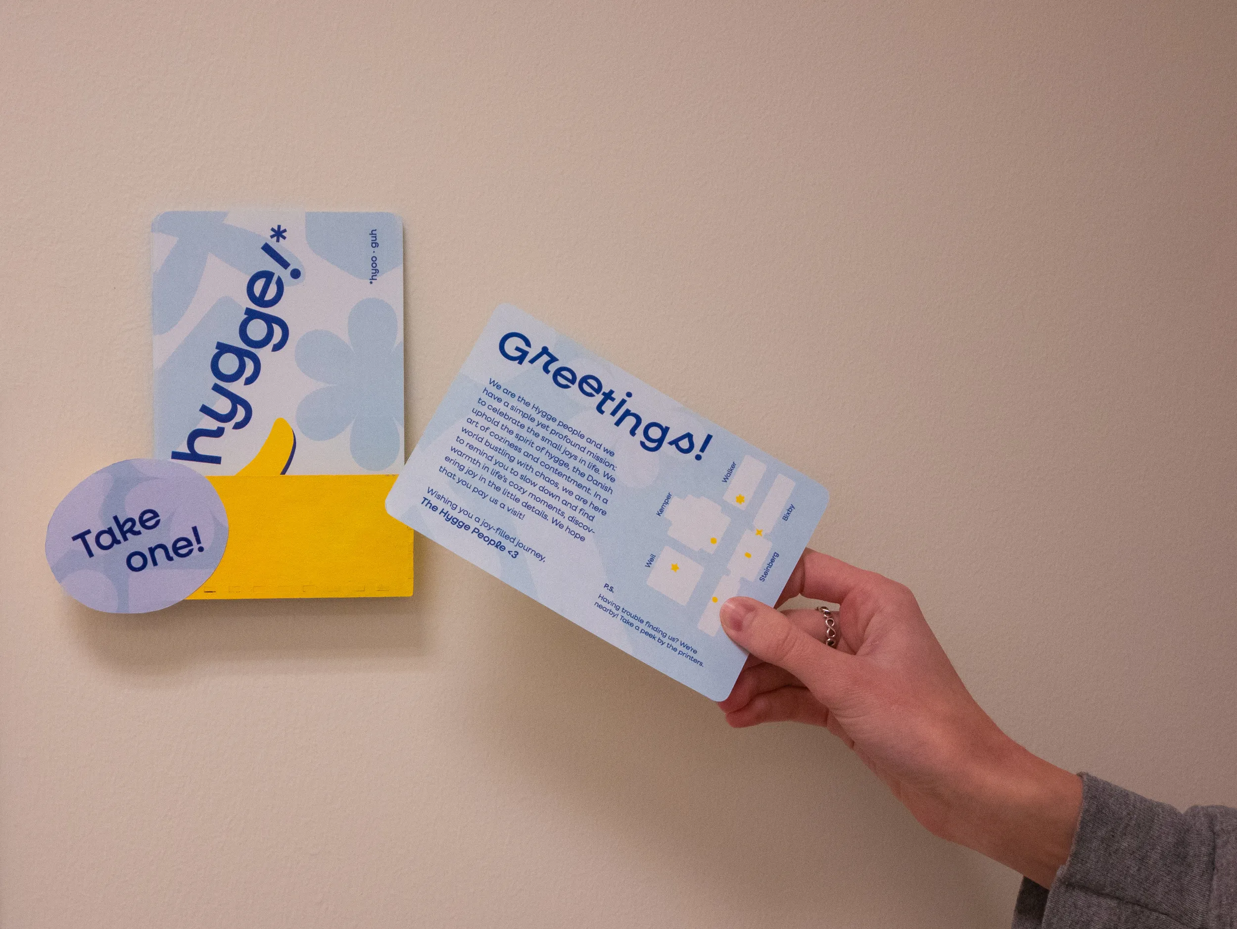 Hand holding back of Hygge postcard